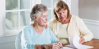 Patientenverfügung und Vorsorgevollmacht, Frau hilft älterer Dame beim Ausfüllen von Unterlagen