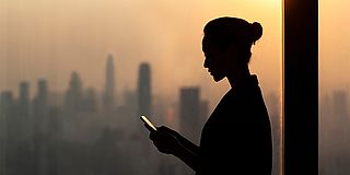 Frauensilhouette vor Skyline im Gegenlicht