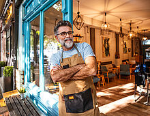 Selbstständiger Handwerker der stolz vor seinem Ladengeschäft steht