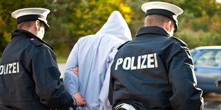 Polizisten führen Zivilisten ab