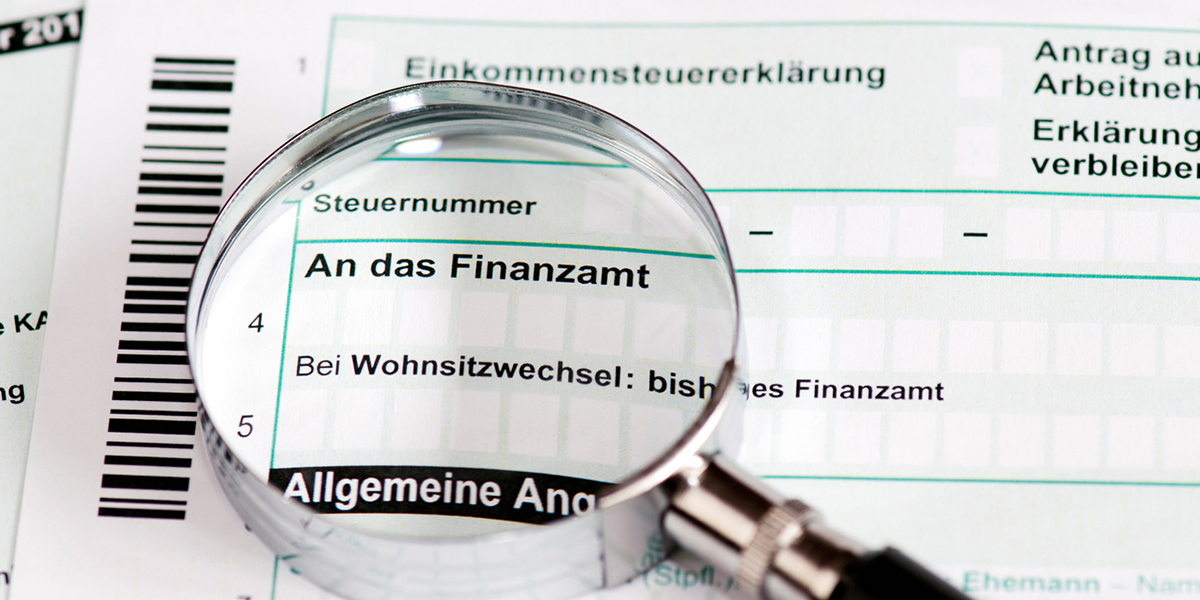 Strafen bei Steuerhinterziehung Dokument an das Finanzamt mit Lupe