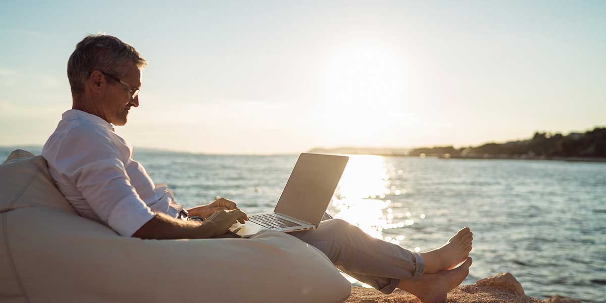Remote Work Remote Work Mann arbeitet mit Laptop am Meer